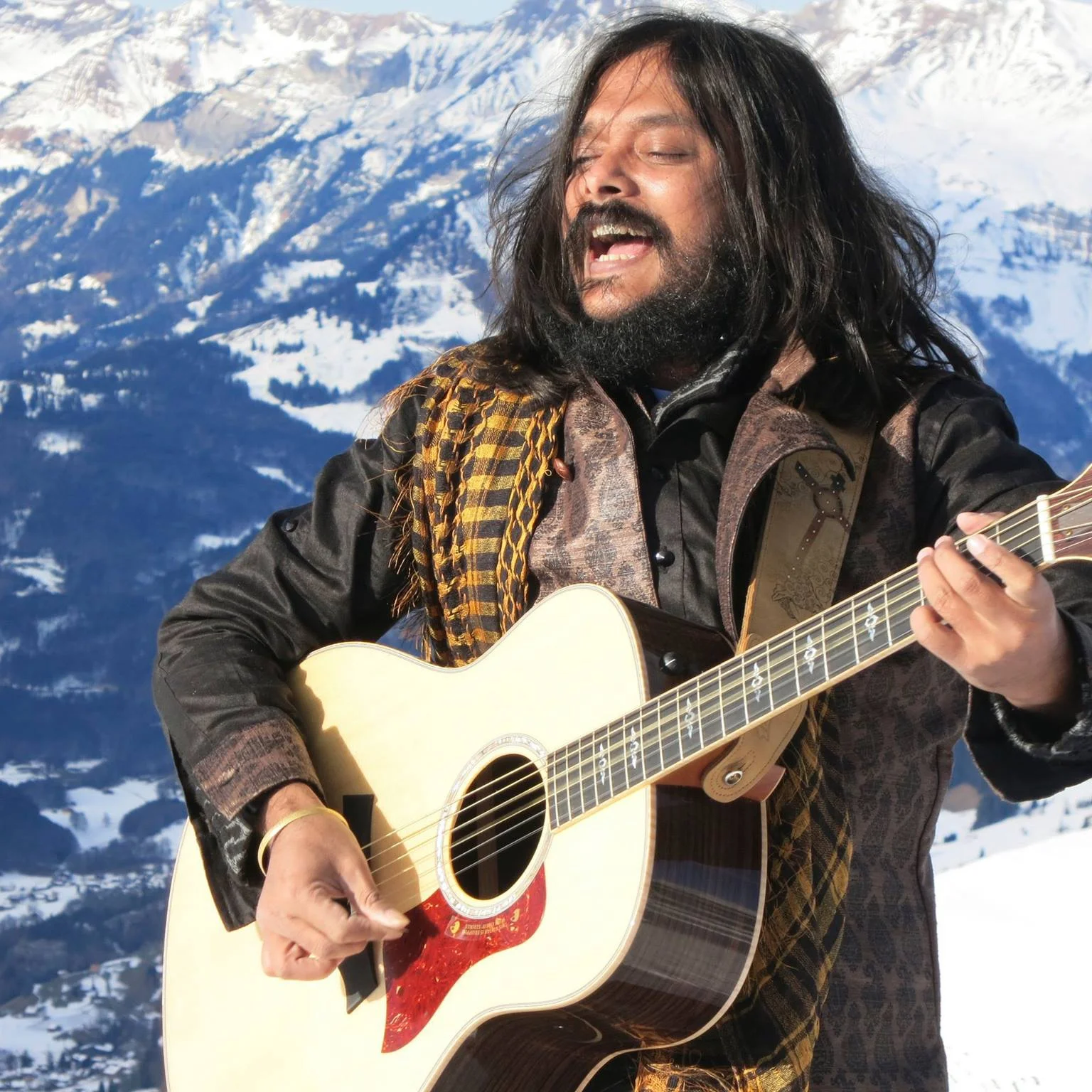 Swami Shrila Prem Paras singing and playing guitar in the mountains